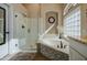 Luxurious bathroom with a glass-enclosed shower, soaking tub, and elegant tile work at 1893 W Canary Way, Chandler, AZ 85286