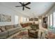 Open-concept living space featuring kitchen, bar, ceiling fan, living room furniture and ample natural light at 1893 W Canary Way, Chandler, AZ 85286