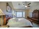 Bedroom featuring a ceiling fan, large windows, and a large wooden bed with decorative pillows at 1893 W Canary Way, Chandler, AZ 85286