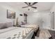 Well-lit bedroom features two beds with warm-toned bedding, complemented by stylish artwork and a ceiling fan at 21 W Beryl Ave, Phoenix, AZ 85021