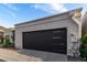 Modern two-car garage with a sleek, dark door and contemporary design elements, set in a desert landscape at 21 W Beryl Ave, Phoenix, AZ 85021