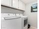Functional laundry room with modern white appliances and ample cabinet space, showcasing a clean and organized area at 21 W Beryl Ave, Phoenix, AZ 85021