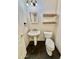 Well-lit half bathroom with a pedestal sink, toilet, and decorative wooden shelves at 2461 E Binner Dr, Chandler, AZ 85225
