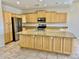 Well-equipped kitchen features stainless steel appliances, granite countertops, a central island, and wood cabinets at 2461 E Binner Dr, Chandler, AZ 85225
