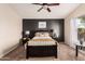 This bedroom offers a ceiling fan, large window with natural light, and a dark accent wall at 2738 E Silversmith Trl, San Tan Valley, AZ 85143