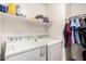 Functional laundry room including washer, dryer, and shelving for organized storage at 2738 E Silversmith Trl, San Tan Valley, AZ 85143