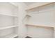 An empty walk-in closet offers wood shelves and rods for plentiful clothing storage at 2738 E Silversmith Trl, San Tan Valley, AZ 85143