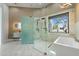 Stylish bathroom featuring a modern glass shower, soaking tub, vanity, and a window with desert views at 28341 N 112Th Way, Scottsdale, AZ 85262