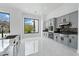 Bright, modern kitchen with gray cabinetry, large windows, and sleek marble floors at 28341 N 112Th Way, Scottsdale, AZ 85262