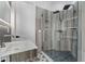 Well-lit bathroom featuring a modern vanity, stylish fixtures, and a glass-enclosed shower with decorative tile at 28341 N 112Th Way, Scottsdale, AZ 85262