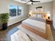 Cozy bedroom showcasing a bed, ceiling fan, wood floors, and lots of natural light at 3134 E Mckellips Rd # 50, Mesa, AZ 85213