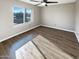 Bright bedroom featuring hardwood floors, large window, fresh paint, and modern lighting at 3134 E Mckellips Rd # 50, Mesa, AZ 85213