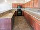 Functional kitchen features granite countertops, wood cabinets, and black appliances at 3134 E Mckellips Rd # 50, Mesa, AZ 85213