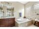 Bright bathroom features a soaking tub with tile surround and granite countertops, offering a relaxing retreat at 3373 E Sports Dr, Gilbert, AZ 85298