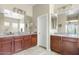 Bathroom with dual vanities, granite counters, warm wood cabinets and large mirrors at 3373 E Sports Dr, Gilbert, AZ 85298