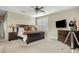 Spacious bedroom with large bed, wood furniture, flatscreen television and plantation shutters at 3373 E Sports Dr, Gilbert, AZ 85298