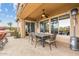 Inviting covered patio with a ceiling fan, elegant dining set, and warm heaters perfect for outdoor entertaining at 3373 E Sports Dr, Gilbert, AZ 85298