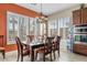 Elegant dining room with plantation shutters, a chandelier, and an adjacent serving station at 3373 E Sports Dr, Gilbert, AZ 85298