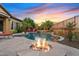 Inviting backyard with a cozy fire pit, pool, spa, and lounge chairs perfect for outdoor gatherings at sunset at 3373 E Sports Dr, Gilbert, AZ 85298