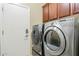 Laundry room includes modern washer and dryer units with cherry wood cabinets for extra storage at 3373 E Sports Dr, Gilbert, AZ 85298