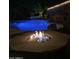 Tranquil backyard at night showcasing a glowing pool and a modern fire pit feature at 3373 E Sports Dr, Gilbert, AZ 85298
