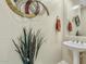 Stylish powder room featuring decorative wall art, mirror, pedestal sink and neutral wall color at 3373 E Sports Dr, Gilbert, AZ 85298