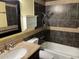 Bathroom featuring decorative tile, granite counters, updated fixtures, vanity storage, and a shower-tub combo at 355 E Thomas Rd # B207, Phoenix, AZ 85012