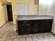 Features modern cabinets and countertops with a light-colored backsplash and classic tile floors at 355 E Thomas Rd # B207, Phoenix, AZ 85012