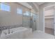 Bathroom featuring a soaking tub, glass shower, decorative tile work and natural light at 36169 N Serrano Ave, Queen Creek, AZ 85140