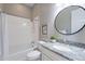 Bathroom featuring a granite countertop, round mirror, bathtub and shower combination at 36169 N Serrano Ave, Queen Creek, AZ 85140