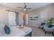 Bedroom with barn door to bathroom, neutral colors, ceiling fan, seating, and king size bed at 36169 N Serrano Ave, Queen Creek, AZ 85140