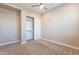 A bright bedroom boasts neutral carpet and paint and features a ceiling fan and closet at 36169 N Serrano Ave, Queen Creek, AZ 85140