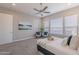 Bedroom with large windows, neutral colors, a ceiling fan, seating, and a king-size bed at 36169 N Serrano Ave, Queen Creek, AZ 85140