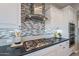 Bright kitchen features a modern range, stylish backsplash, and white cabinets at 36169 N Serrano Ave, Queen Creek, AZ 85140