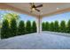 View of the patio with a ceiling fan and view of the yard, lined with decorative bushes at 36169 N Serrano Ave, Queen Creek, AZ 85140