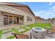 An inviting backyard features concrete pavers, a barbecue, a fire pit, and artificial grass at 3859 E Appaloosa Rd, Gilbert, AZ 85296