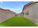 Spacious backyard featuring artificial grass, pavers, and a view of the home's exterior at 3859 E Appaloosa Rd, Gilbert, AZ 85296