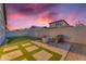 Serene backyard featuring artificial turf, a stone patio with pavers, a fire pit, and a built-in BBQ grill at 3859 E Appaloosa Rd, Gilbert, AZ 85296