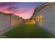 Expansive backyard with artificial turf, a stone patio, and block wall fencing, offering a private outdoor space at 3859 E Appaloosa Rd, Gilbert, AZ 85296