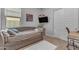 Neutral bedroom with a sofa bed, white rug, mounted TV, and modern décor at 3859 E Appaloosa Rd, Gilbert, AZ 85296