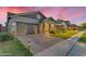 Attractive home with a well-maintained lawn, stone accents, and a brick driveway leading to a two-car garage at 3859 E Appaloosa Rd, Gilbert, AZ 85296
