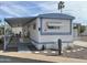 Charming mobile home with desert landscaping, covered porch, and a light blue trim on a sunny day at 4065 E University Dr # 88, Mesa, AZ 85205