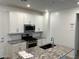 Well-appointed kitchen featuring a granite island, stainless appliances, and white cabinets at 4077 S Sabrina Dr # 94, Chandler, AZ 85248