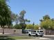Exterior shot with a police car in front of a gated community entrance with mature trees under clear blue skies at 5601 E Monte Cristo Ave, Scottsdale, AZ 85254