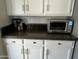 Countertop with toaster oven, coffee maker, white cabinets, and dark backsplash at 5601 E Monte Cristo Ave, Scottsdale, AZ 85254