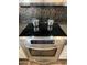 Stainless steel range oven with glass top cooktop and mosaic tile backsplash at 5601 E Monte Cristo Ave, Scottsdale, AZ 85254