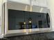 Close up of Samsung stainless steel microwave above range with reflective black glass at 5601 E Monte Cristo Ave, Scottsdale, AZ 85254