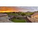 Beautiful backyard featuring lush grass, a playset, a pool, and scenic views of the surrounding landscape at sunset at 608 E Pasaro Dr, Phoenix, AZ 85085