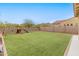 Large backyard with synthetic grass, play equipment, and block wall fence at 608 E Pasaro Dr, Phoenix, AZ 85085