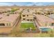 Aerial view of a backyard with lush green lawn, a patio, playground, and a sparkling pool at 608 E Pasaro Dr, Phoenix, AZ 85085